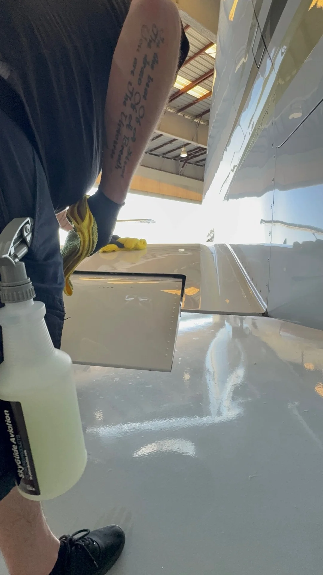 SkyWorkPros technician polishing aircraft exterior in hangar